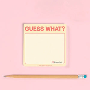 Notepad with 'Guess What?' text and a pencil on a pink background