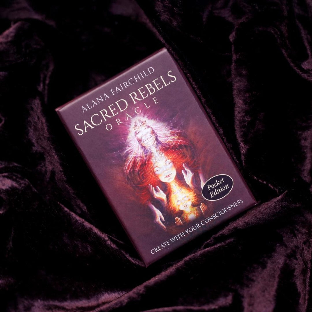 pocket edition of Sacred Rebels Oracle card deck on a dark fabric background