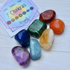 Set of colorful crystals with a card labeled '7 Chakras' on a white surface