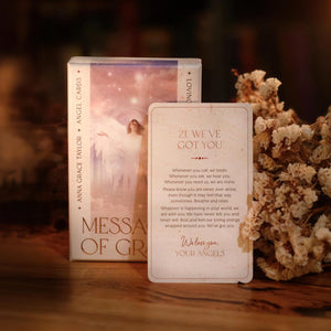 Card with angelic design and text on a wooden surface with flowers