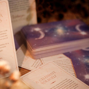 Stack of tarot cards with a focus on one card reading 'Celebrate Yourself'.