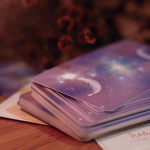 Stack of tarot cards with a mystical design on a wooden surface