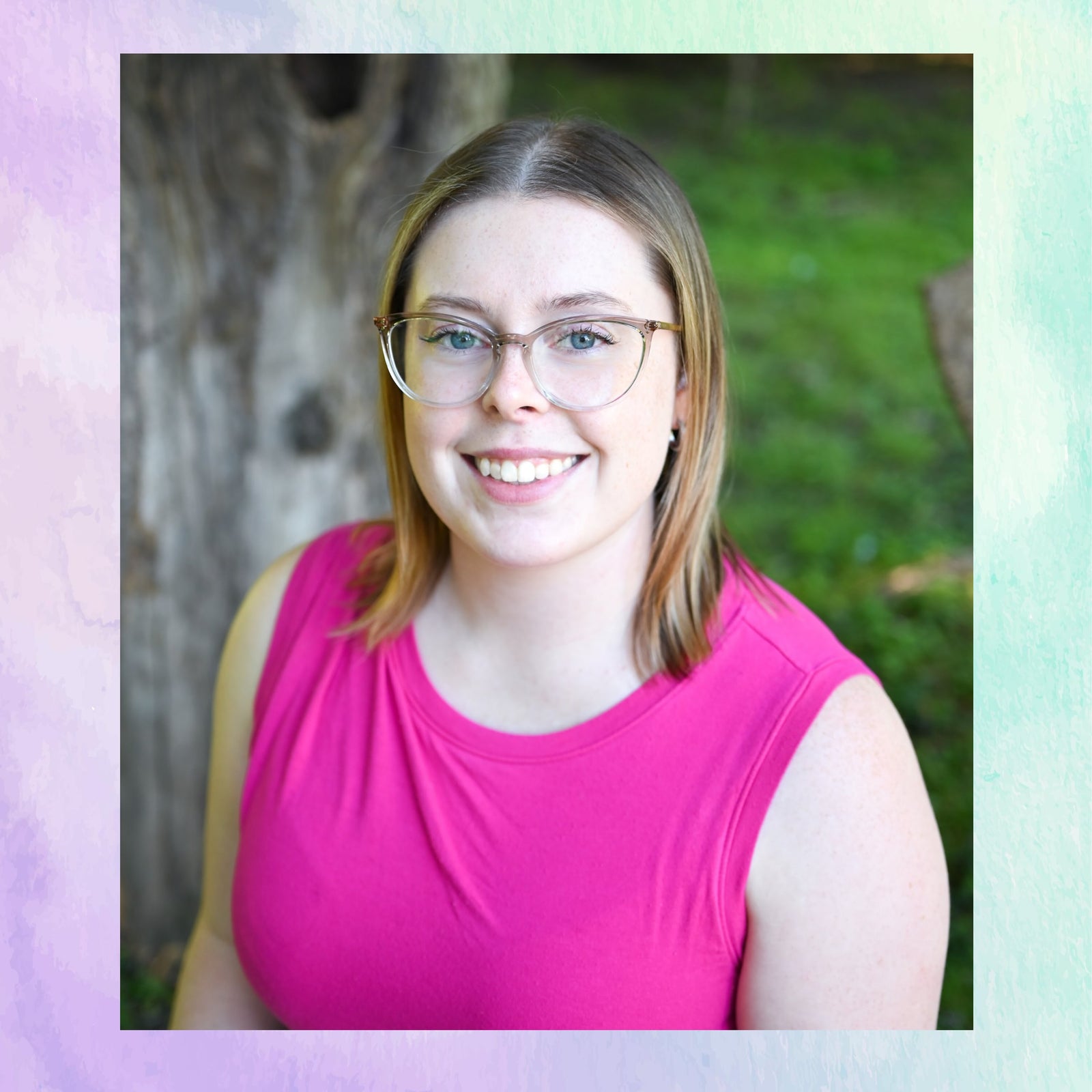 Woman wearing glasses and a pink shirt with a blurred green background
