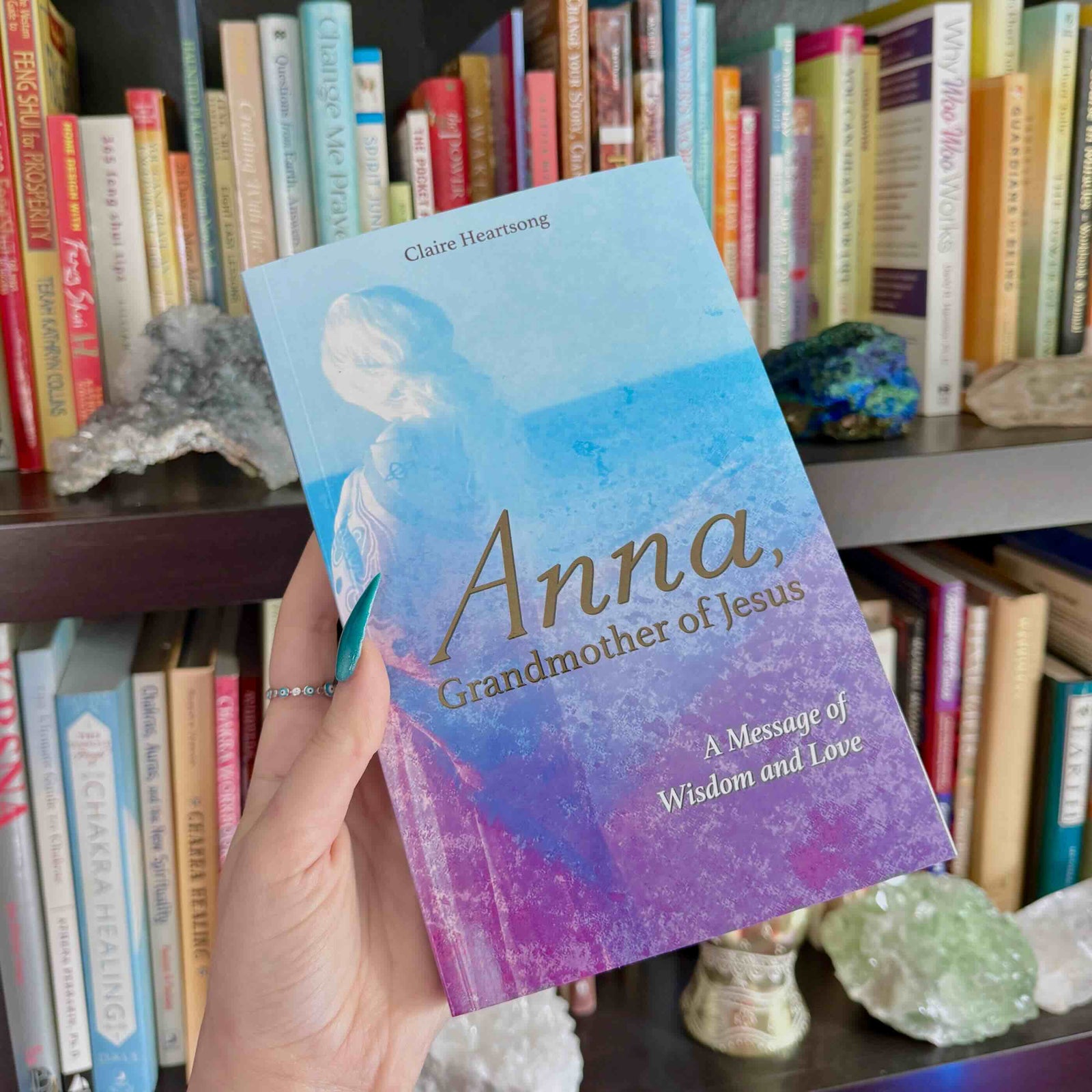 Book titled 'Anna, Grandmother of Jesus' held in front of a bookshelf.
