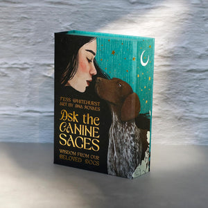 A teal boxed card deck titled “Ask the Canine Sages’ in gold text with a woman and dog illustration on a textured background.