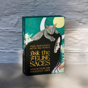 A boxed card deck titled "Ask the Feline Sages" in gold text with artwork of a gray cat resting on a woman's shoulders, with teal, black, and cream.