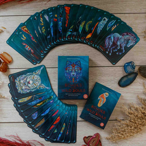 Fanned deck of 'Echoes Wild Souls' oracle cards on a wooden surface with the guidebook and box.