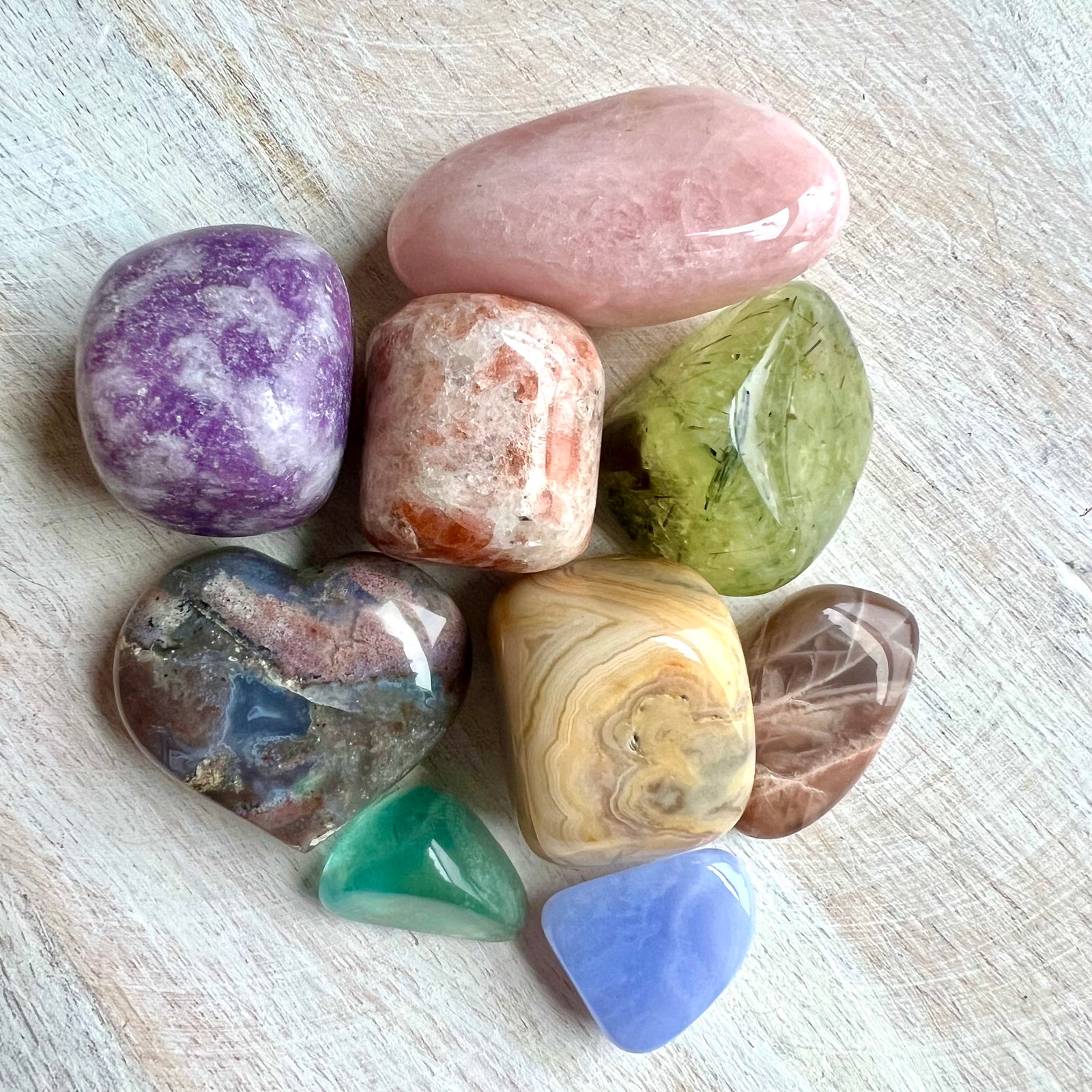 9 pocket sized crystals on white wood background