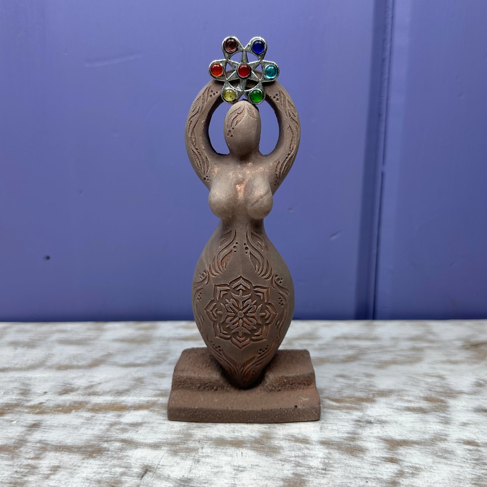 four goddess cement statues with arms over head in a circle