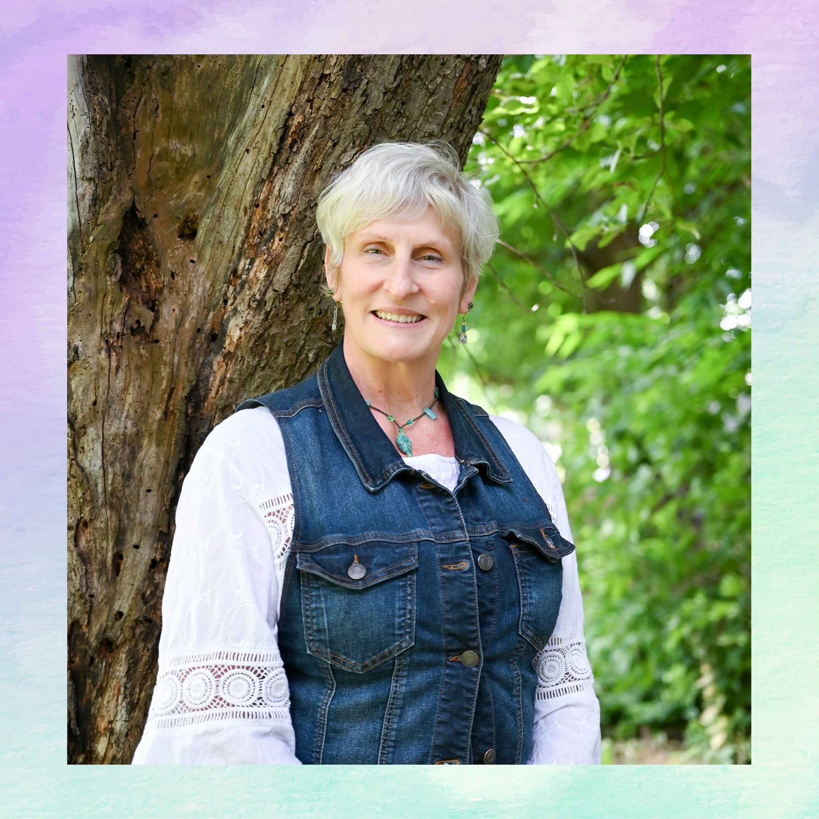 Woman standing next to a tree with greenery in the background