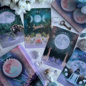 Collection of oracle cards with moon phases and nature imagery on a textured surface.