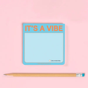 Notepad with 'IT'S A VIBE' text on a pink background with a pencil.
