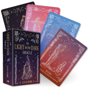 Set of oracle cards titled 'The Light in the Dark Oracle' by Lucia Dami, with colorful card backs featuring celestial designs.