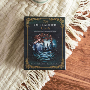 The Outlander Oracle card deck on cream colored fabric and wood