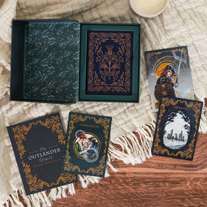 The Outlander Oracle card deck and guidebook on a wooden surface with oracle cards.