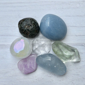 Collection of various crystals on a light wooden surface