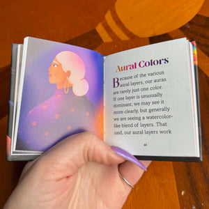 small Open book with illustration of a person and text on a wooden surface