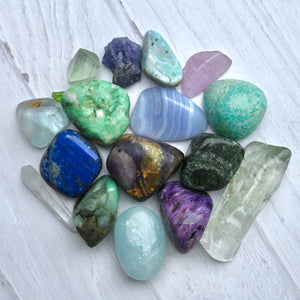 Assorted colorful crystals on a light wooden surface