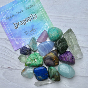 Colorful crystals on a white surface with a 'Dragonfly' card in the background