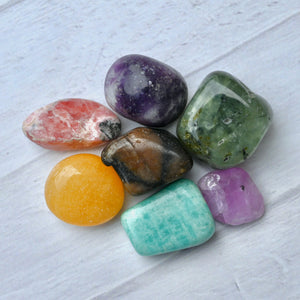 Assorted colorful crystals on a light wooden surface