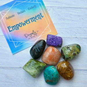 Colorful crystals on a white surface with an 'Empowerment' card in the background.