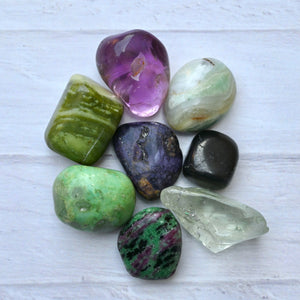 Assorted colorful crystals on a light wooden surface