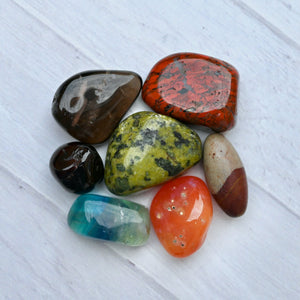 Collection of colorful stones on a white wooden surface