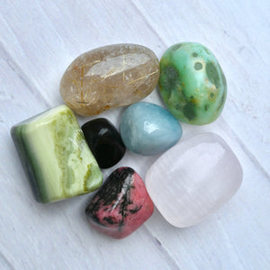 Collection of colorful stones on a white wooden surface