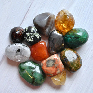 Assorted colorful tumbled stones on a white surface