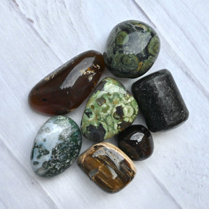 Collection of polished gemstones on a white wooden surface