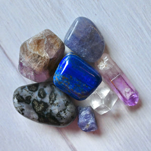 Collection of various colorful crystals on a light wooden surface