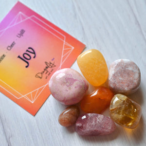 Colorful stones on a white surface with a card in the background