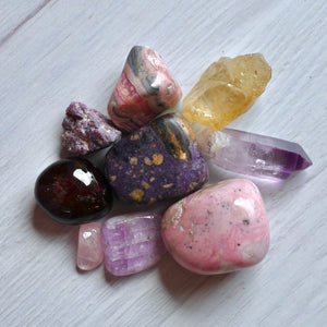 Assorted colorful crystals on a light wooden surface