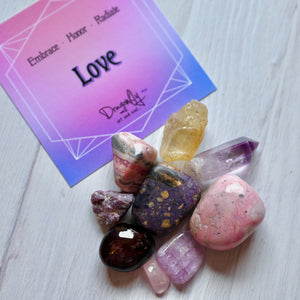 Colorful crystals on a white surface with a 'Love' card in the background