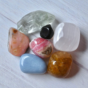 Collection of various colorful crystals on a light wooden surface