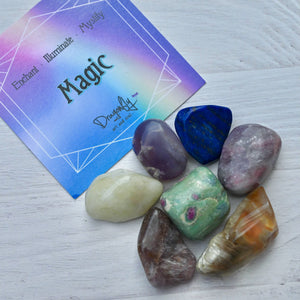 Set of colorful crystals with a card labeled 'Mystic' on a light wooden surface.