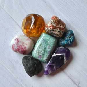 Collection of various colorful crystals on a white surface