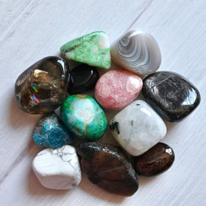 Assorted colorful stones on a light wooden surface