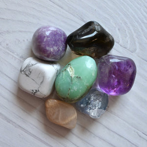 Collection of multicolored crystals on a light wooden surface