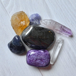 Collection of various crystals on a white wooden surface