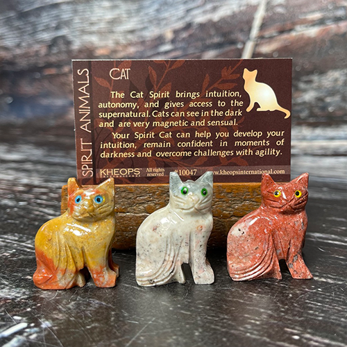 Three small bear figurines, crafted from differently colored stones, are displayed in front of a card. The card reads: "The Bear Spirit brings peace, modesty and benevolence. Bears are brave and defend their offspring. They have a very strong motherly nature." Each Spirit Animal holds a unique meaning as your spirit animal.